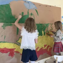 Dzieci malują wielki mural na ścianie